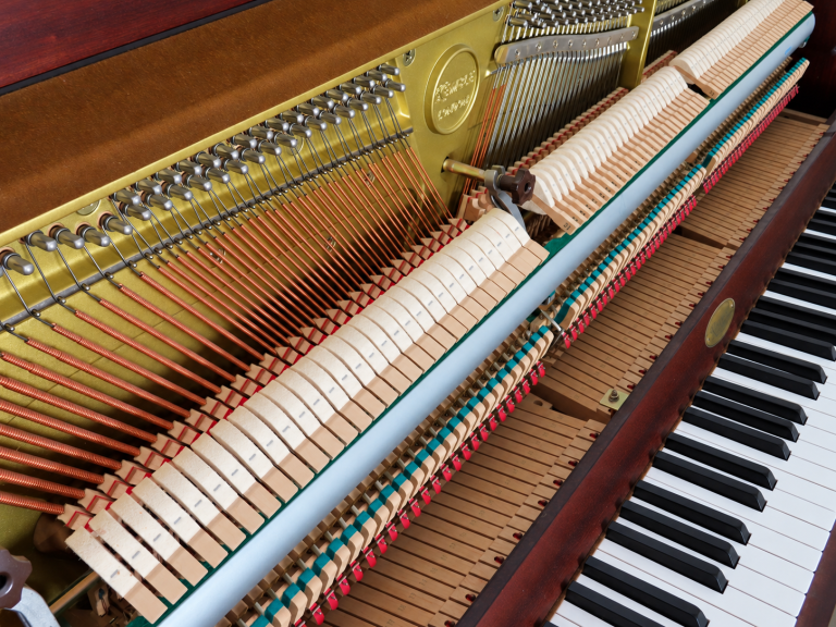 Exposed upright piano mechanism in warm detail